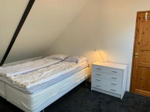 ein Schlafzimmer mit einem Bett und eine Kommode mit einer Lampe in der Unterkunft Navröds Gård in Sjöbo