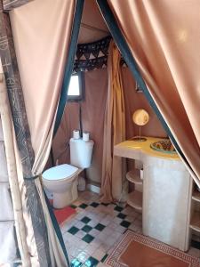 a bathroom with a toilet in a tent at Merzouga Luxury Tented Camp in Merzouga