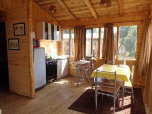 a kitchen with a table and chairs in a cabin at Cabañas de la Laguna in Parral