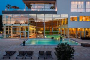 un gran edificio con una piscina frente a él en Golf & Relax Apartment mit 4*S-Anbindung, en Bad Waltersdorf