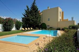 a swimming pool in front of a house at Casinha do Sol in Almancil