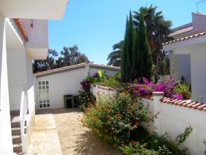 a white house with flowers and a fence at Apartment Los Eucaliptus in L'Eucaliptus