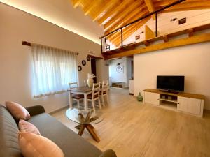 ein Wohnzimmer mit einem Sofa und einem Tisch mit einem TV in der Unterkunft Casa De Los Silos 