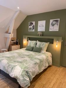 - une chambre avec un grand lit aux murs verts dans l'établissement Au fil de l’Ô, à Bisseuil