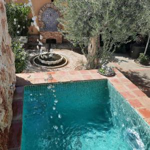 a swimming pool with a fountain in a yard at Beautiful Alamedas: casa rural con piscina in Castronuño