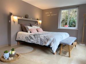 a bedroom with a bed with pink pillows and a window at Au fil de l’Ô in Bisseuil