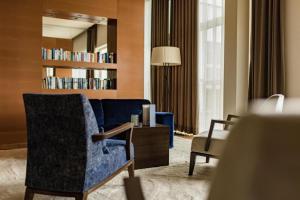 sala de estar con sofá azul y silla en Golf & Relax Apartment mit 4*S-Anbindung, en Bad Waltersdorf