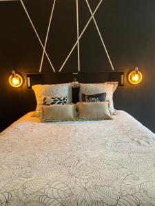 - une chambre dotée d'un grand lit avec deux lumières dans l'établissement Au fil de l’Ô, à Bisseuil