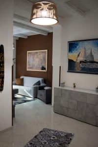 a living room with a couch and a chandelier at Kasbah Apartment in Mazara del Vallo