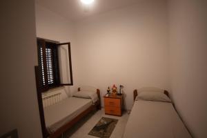 a bedroom with two beds and a window and a table at Kasbah Apartment in Mazara del Vallo