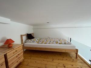 ein Schlafzimmer mit einem Bett und einer Holzkommode in der Unterkunft Vito Apartman in Eger