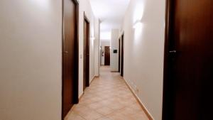 un pasillo con una fila de puertas y suelo de baldosa en Hotel Piscina La Suite, en Prossedi