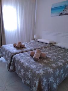 プラヤ・デ・ラス・アメリカスにあるTorres de Yomely Playa las Americasのベッドルームにタオル付きのベッド2台が備わります。