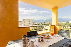 une table avec une assiette de nourriture sur un balcon dans l'établissement Trivano Villasimius, à Villasimius