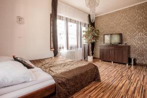 a bedroom with a bed and a flat screen tv at Villa Cztery Strony Świata in Zakopane