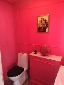 a red bathroom with a toilet and a picture on the wall at Mojo organic spa in Borgholm