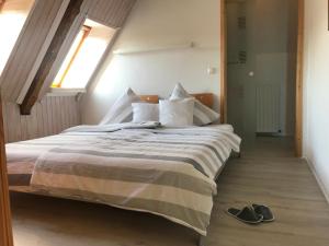 a bedroom with a bed with a pair of shoes on the floor at Hof Seebrookquelle in Schlesen
