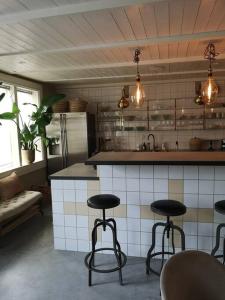 a kitchen with three bar stools in front of a counter at Mojo organic spa in Borgholm