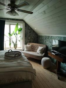 a bedroom with a bed and a couch and a window at Mojo organic spa in Borgholm