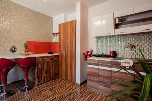 a kitchen with white cabinets and red stools at Villa Cztery Strony Świata in Zakopane