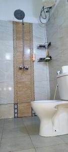 een badkamer met een douche, een toilet en een douche bij Cambric Luxe Studio Apartment in Kilifi