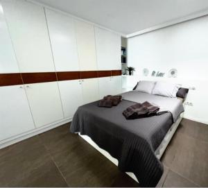 een slaapkamer met een groot bed en witte kasten bij Apartamento Playa chica, vistas al mar Lanzarote in Puerto del Carmen