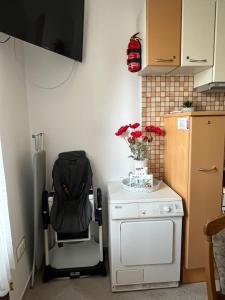 Il comprend une petite cuisine avec une chaise et un réfrigérateur. dans l'établissement Vito Apartman, à Eger