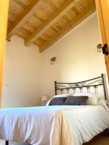 Schlafzimmer mit einem Bett mit Holzdecke in der Unterkunft LA PORTADA DE ABAJO in Gallegos