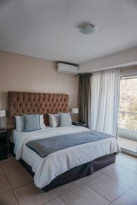 een slaapkamer met een groot bed en een groot raam bij Aqualina Suites in Valeria del Mar
