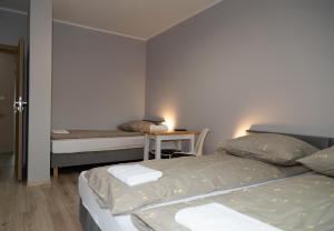 a bedroom with two beds and a table with a desk at Zajazd u ELiZY in Czajowice