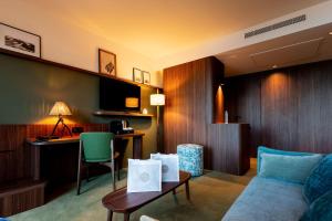 佩羅斯－吉雷克的住宿－Hôtel Roz Marine Thalasso Resort，客厅配有沙发、桌子和书桌