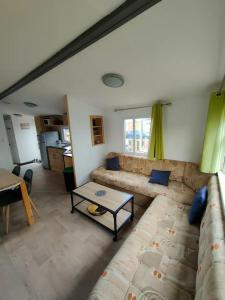 a living room with a couch and a table at Le Cocooning in Biville-sur-Mer