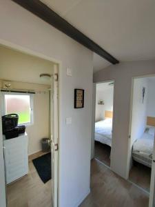 Habitación con dormitorio con cama y espejo. en Le Cocooning, en Biville-sur-Mer