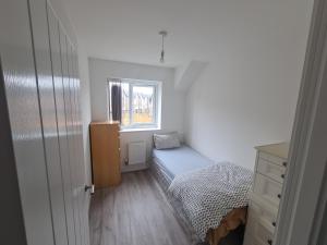 a small bedroom with a bed and a window at lovely new home in manchester close to MANCHESTER CITY FC in Manchester
