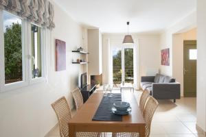 a living room with a wooden table and chairs at Alegria Boutique Villas in Lygia