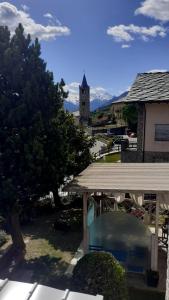 a view of a house with a pool and a church at lo Tsanty in Aosta