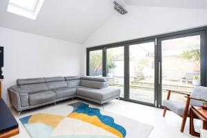 a living room with a couch and a large window at The Art House by Sorted Stay in Woodham Ferrers