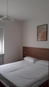 a bedroom with a white bed with a wooden headboard at lo Tsanty in Aosta