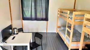 a room with a desk and bunk beds at Rakamaz Tisza Kemping in Rakamaz