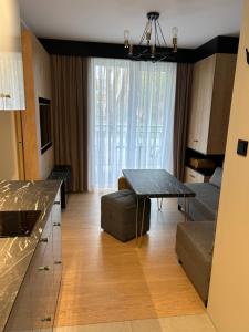 ein Wohnzimmer mit einem Tisch und einem Sofa in der Unterkunft Lazurowy Apartament in Łeba