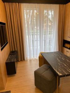 ein Wohnzimmer mit einem Tisch und einem Sofa in der Unterkunft Lazurowy Apartament in Łeba