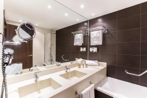 
a bathroom with two sinks and a mirror at Vincci Resort Costa Golf in Chiclana de la Frontera
