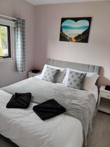 a bedroom with a bed with two black towels on it at Bay View Villas in Bucks Mills