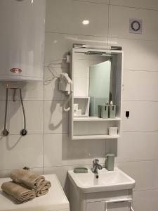 Baño blanco con lavabo y espejo en Apartment Deluxe, en Peje