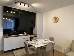 a kitchen with a white table and chairs in a room at Apartment Deluxe in Peje