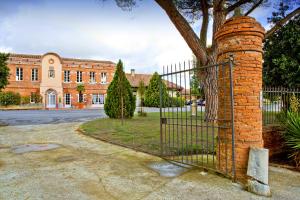 an iron gate in front of a brick building at Best Western Plus Le Canard sur le Toit in Colomiers