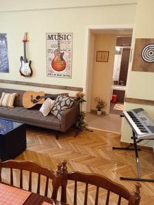 een woonkamer met een bank en een piano bij Still got the blues in Athene