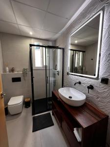 y baño con lavabo, aseo y espejo. en Luxury new 6 pax apart Downtown. en Córdoba