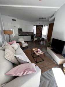 uma sala de estar com um sofá branco e uma mesa em Luxury new 6 pax apart Downtown. em Córdoba