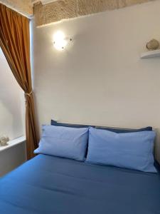 Una cama con almohadas azules en un dormitorio en Dimora Serena, en Ostuni 18 fotos más
